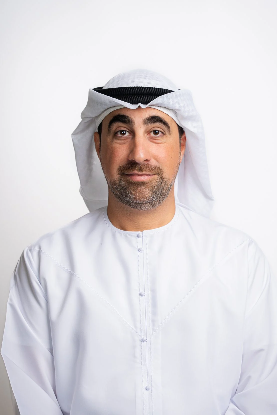 Corporate headshot of an Emirati man in a white kandura