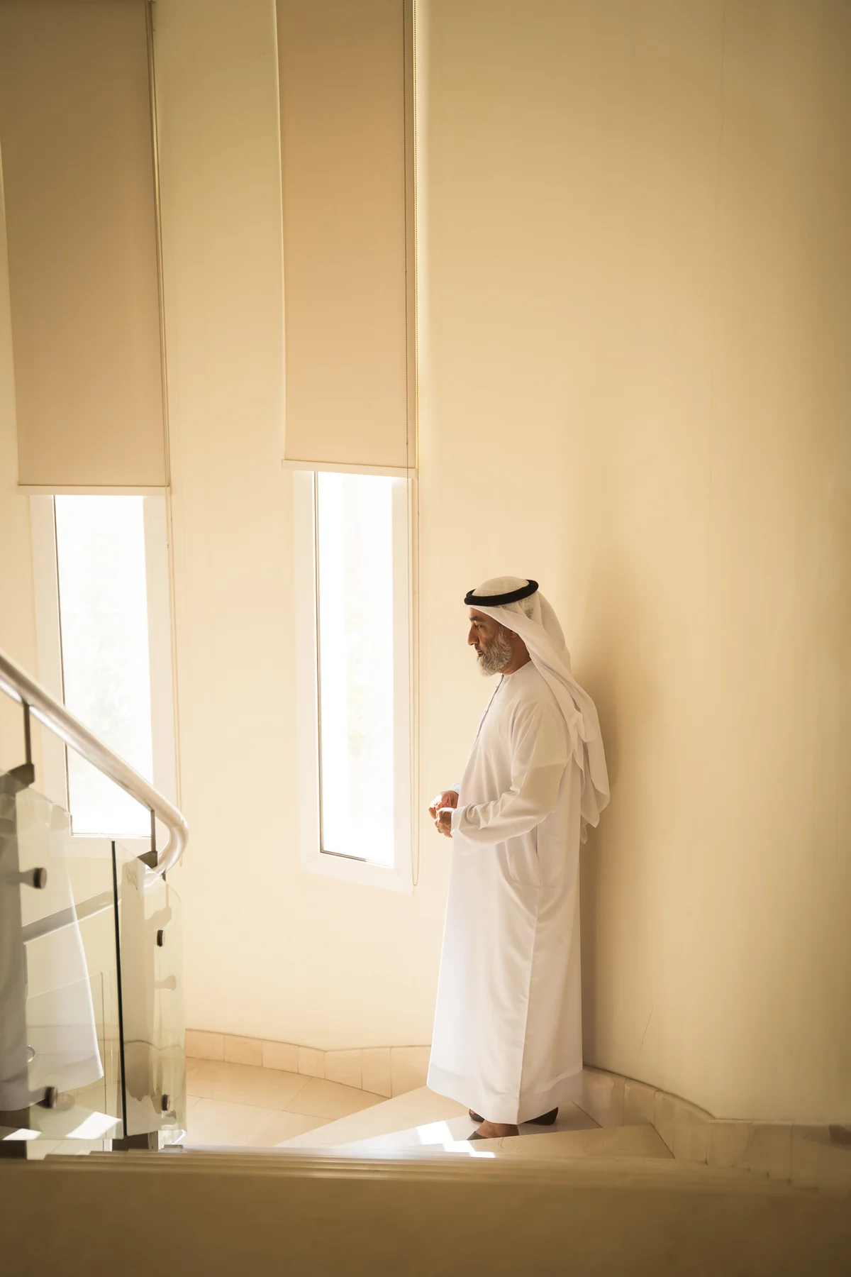 Emirati groom waiting by a window in warm light