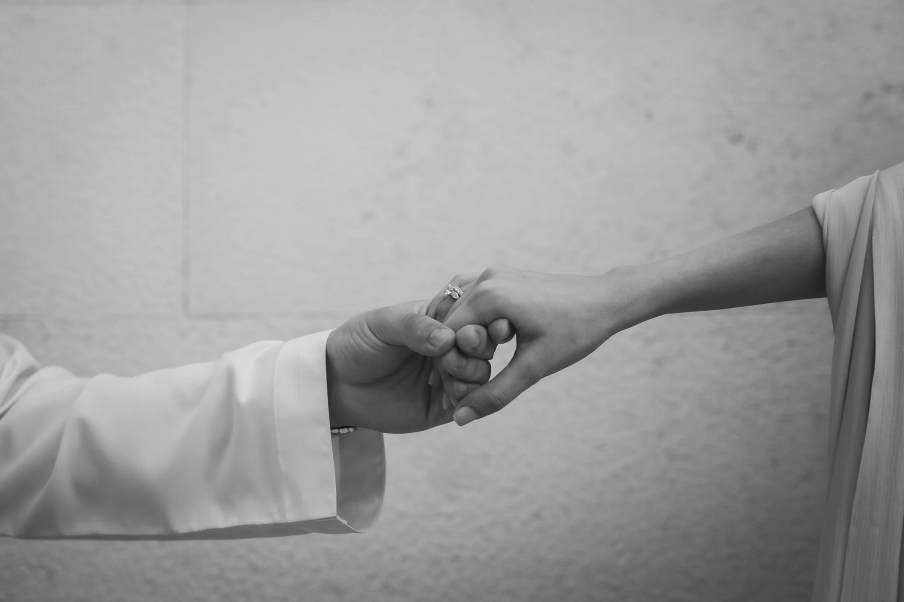 Two hands reaching for each other, black and white