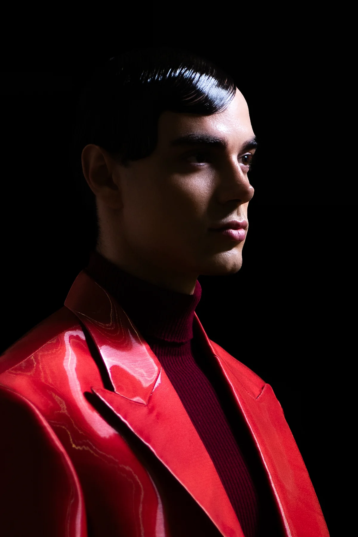 Man in a red leather jacket against black