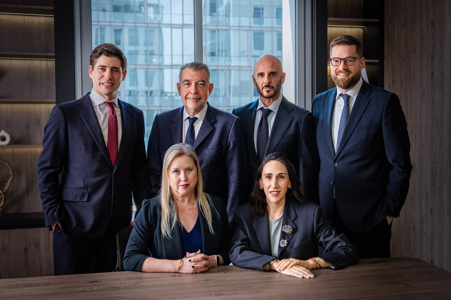 Law firm team portrait around a boardroom table with city views