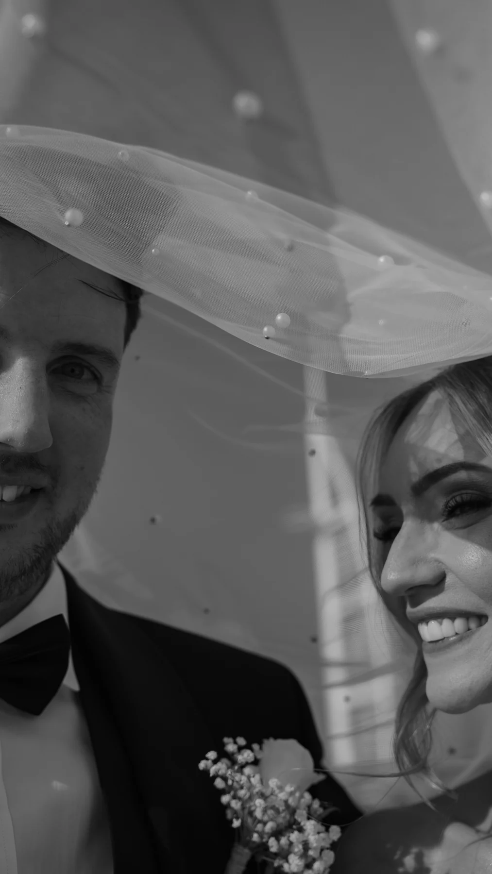 Couple smiling under the veil, black and white