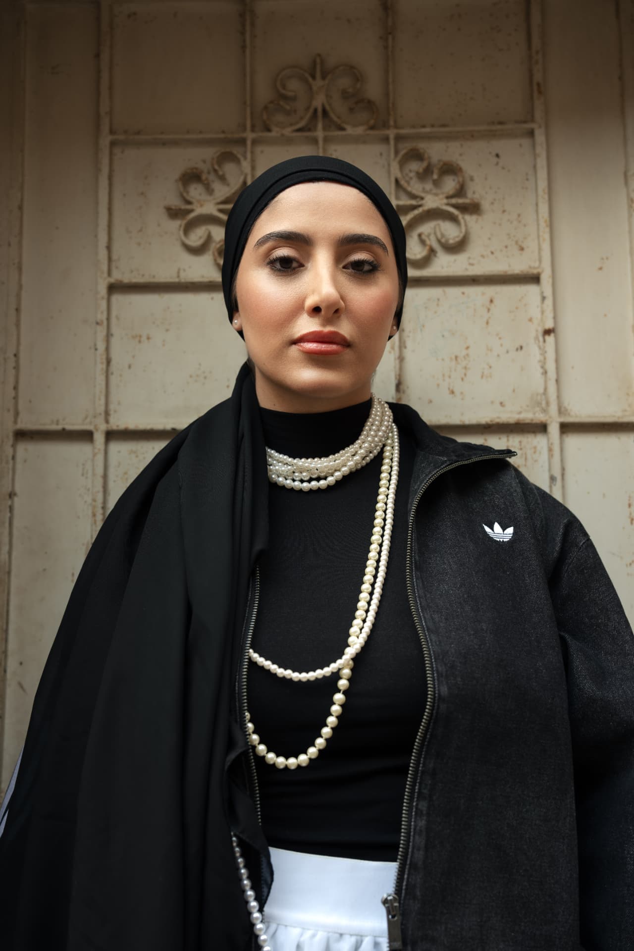 Close portrait in black Adidas jacket and pearls