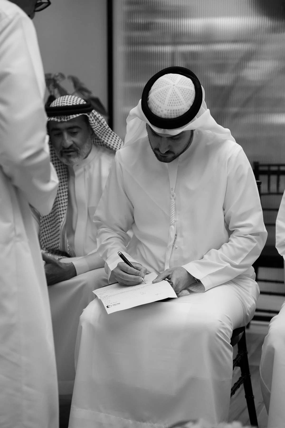 Groom signing at the melcha, black and white