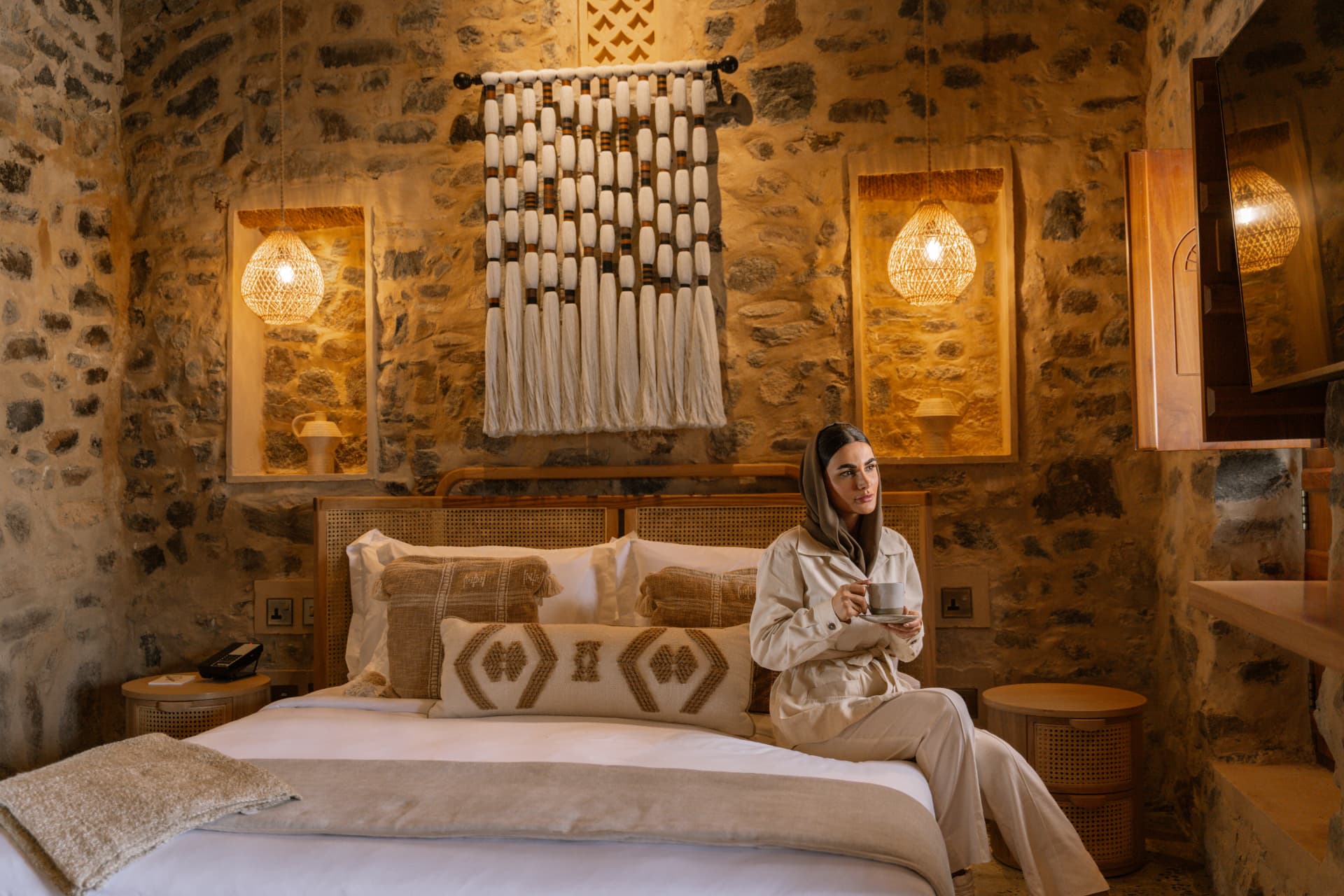 Woman relaxing on a bed in a stone heritage room