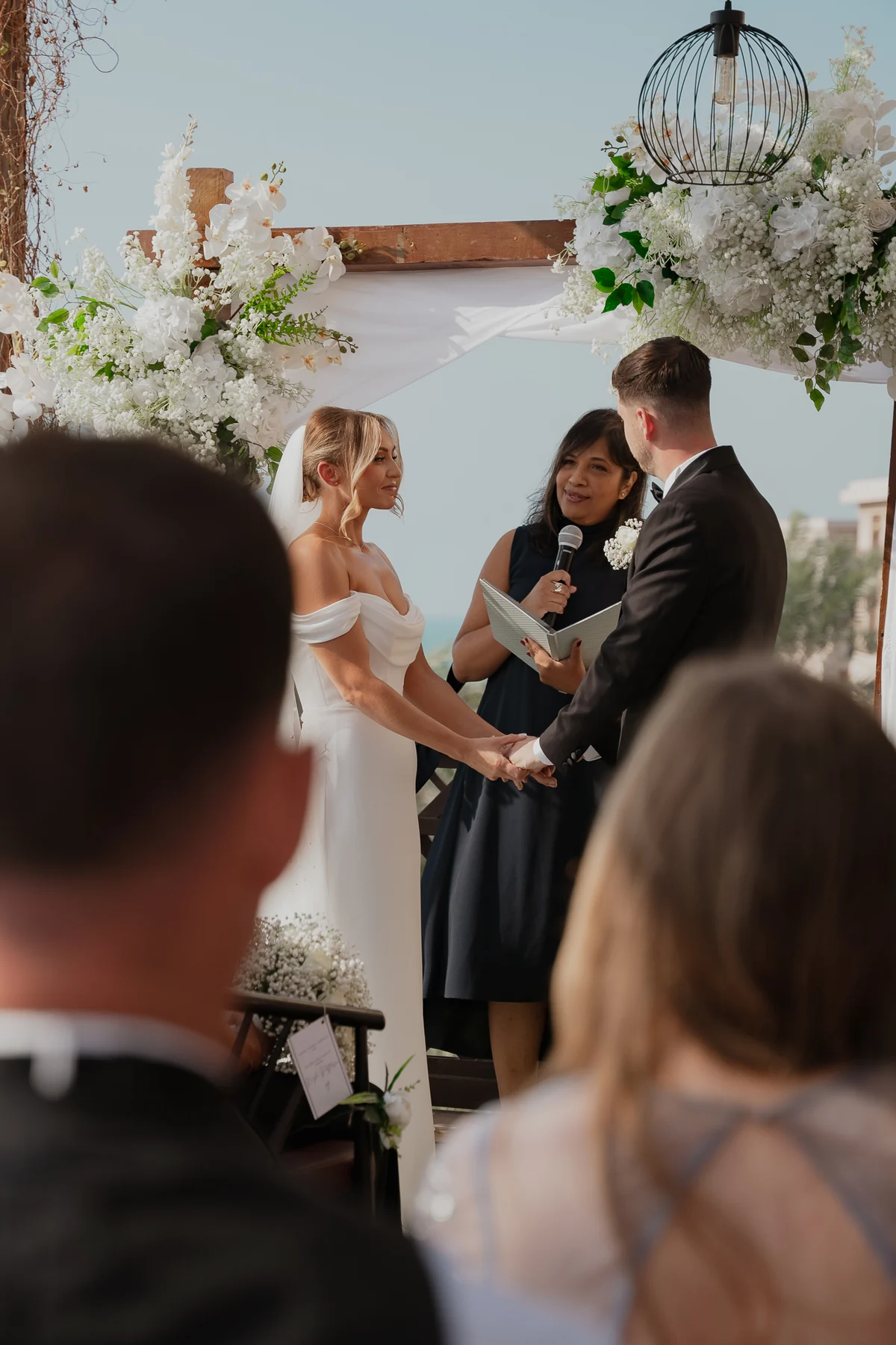 Couple exchanging vows under a flower arch