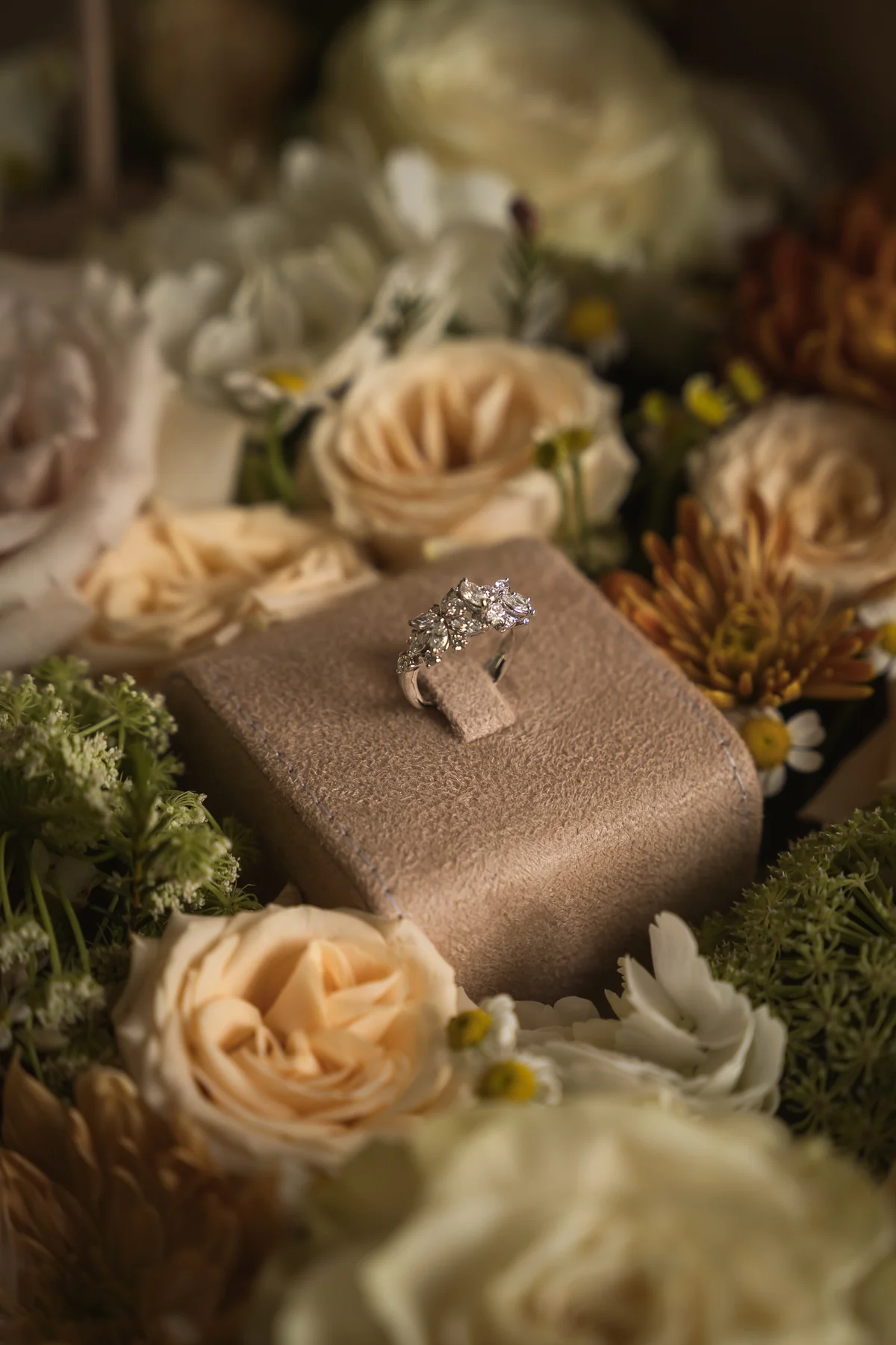 Engagement ring in a box among roses