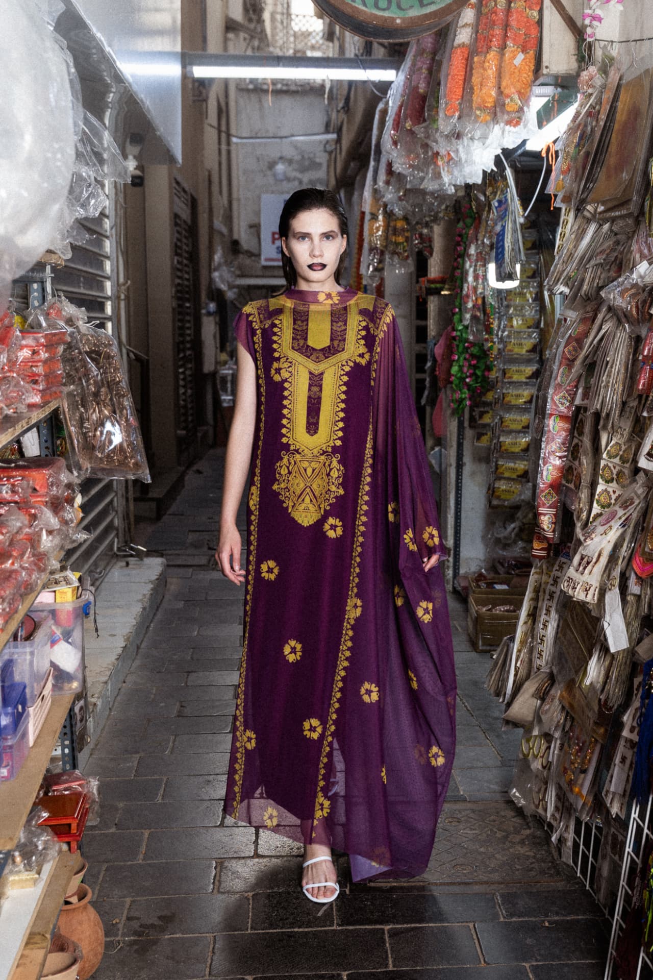 Model in purple embroidered kaftan in a narrow souk alley