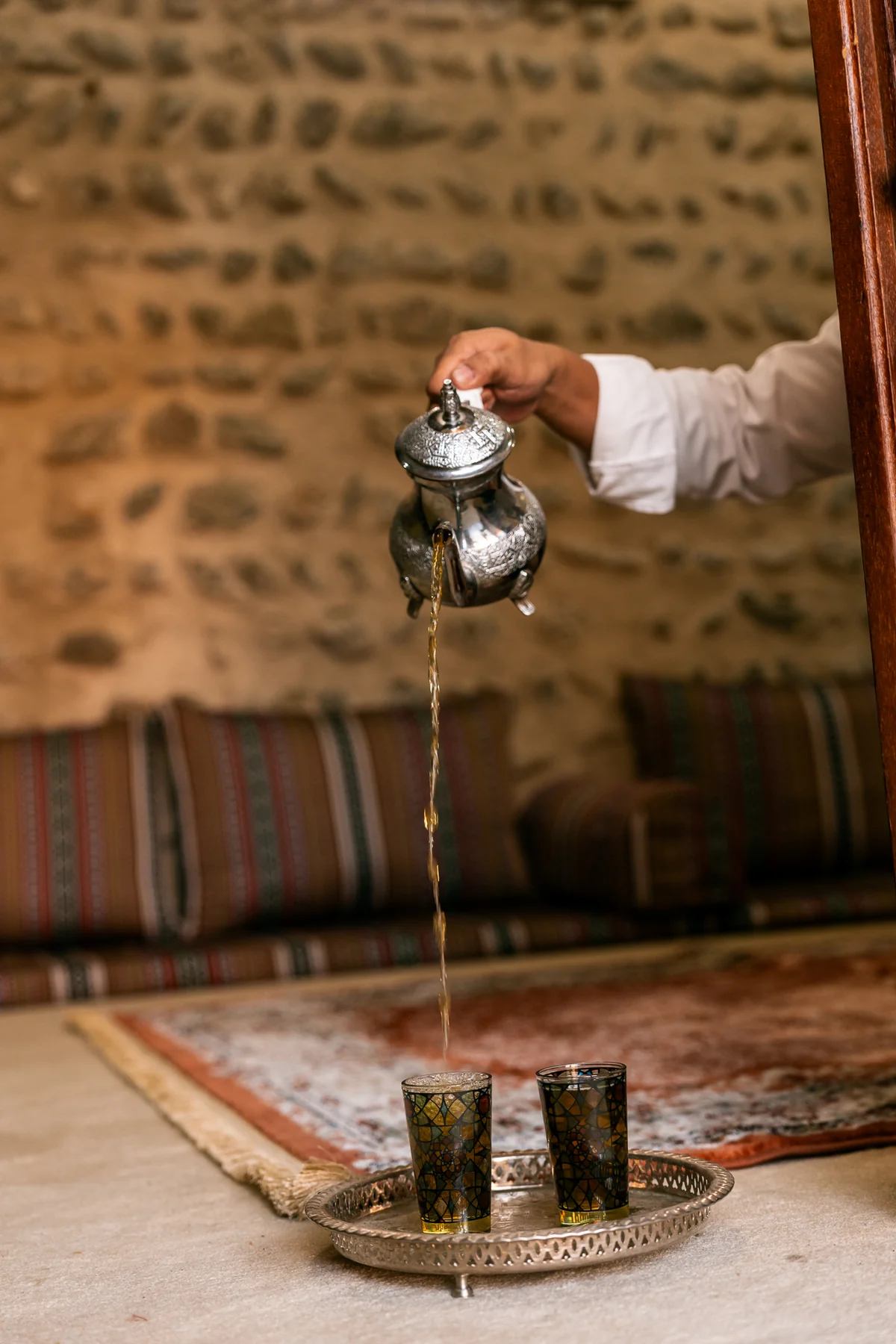 Pouring mint tea from a silver pot
