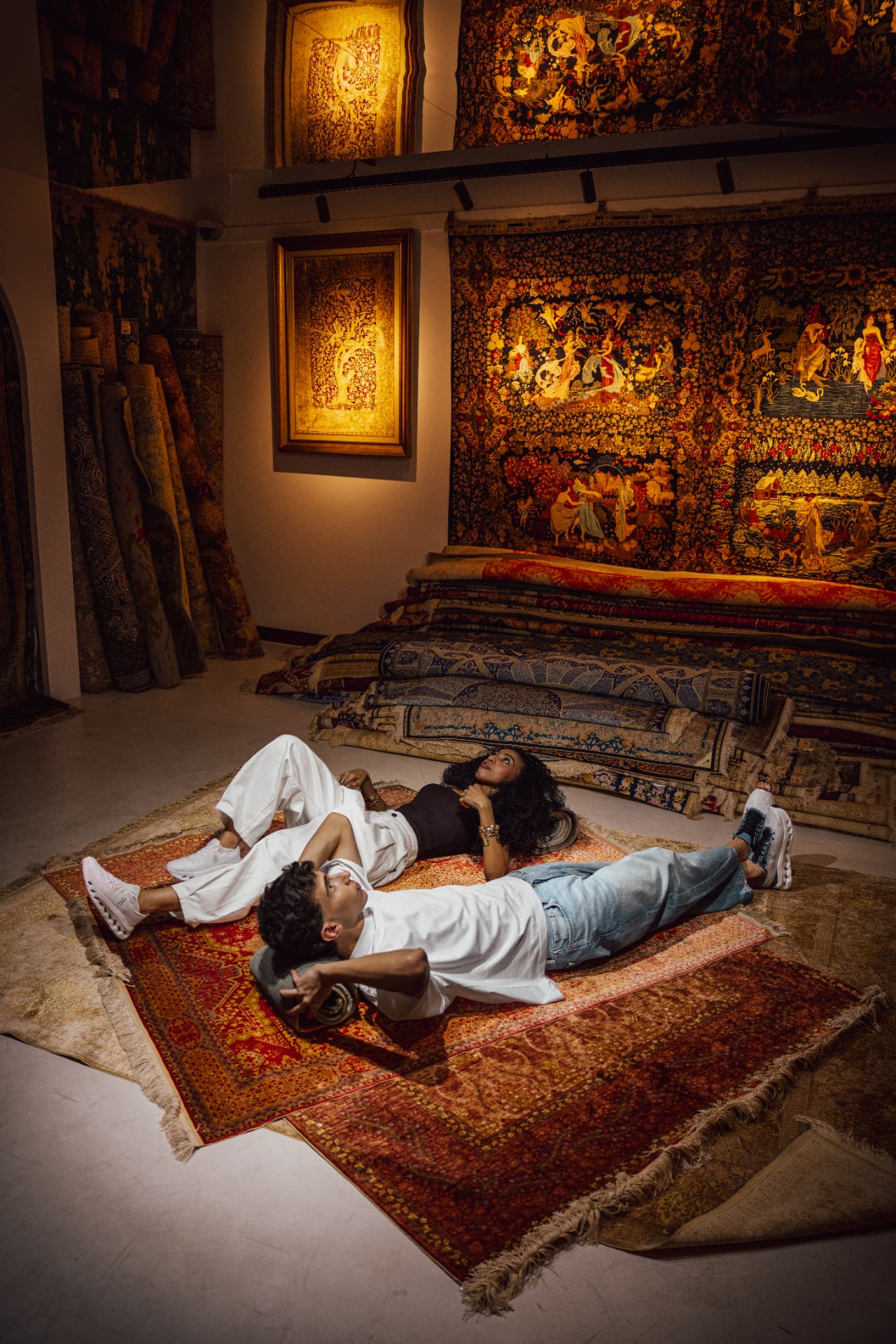 Two models lying on rugs in a carpet gallery