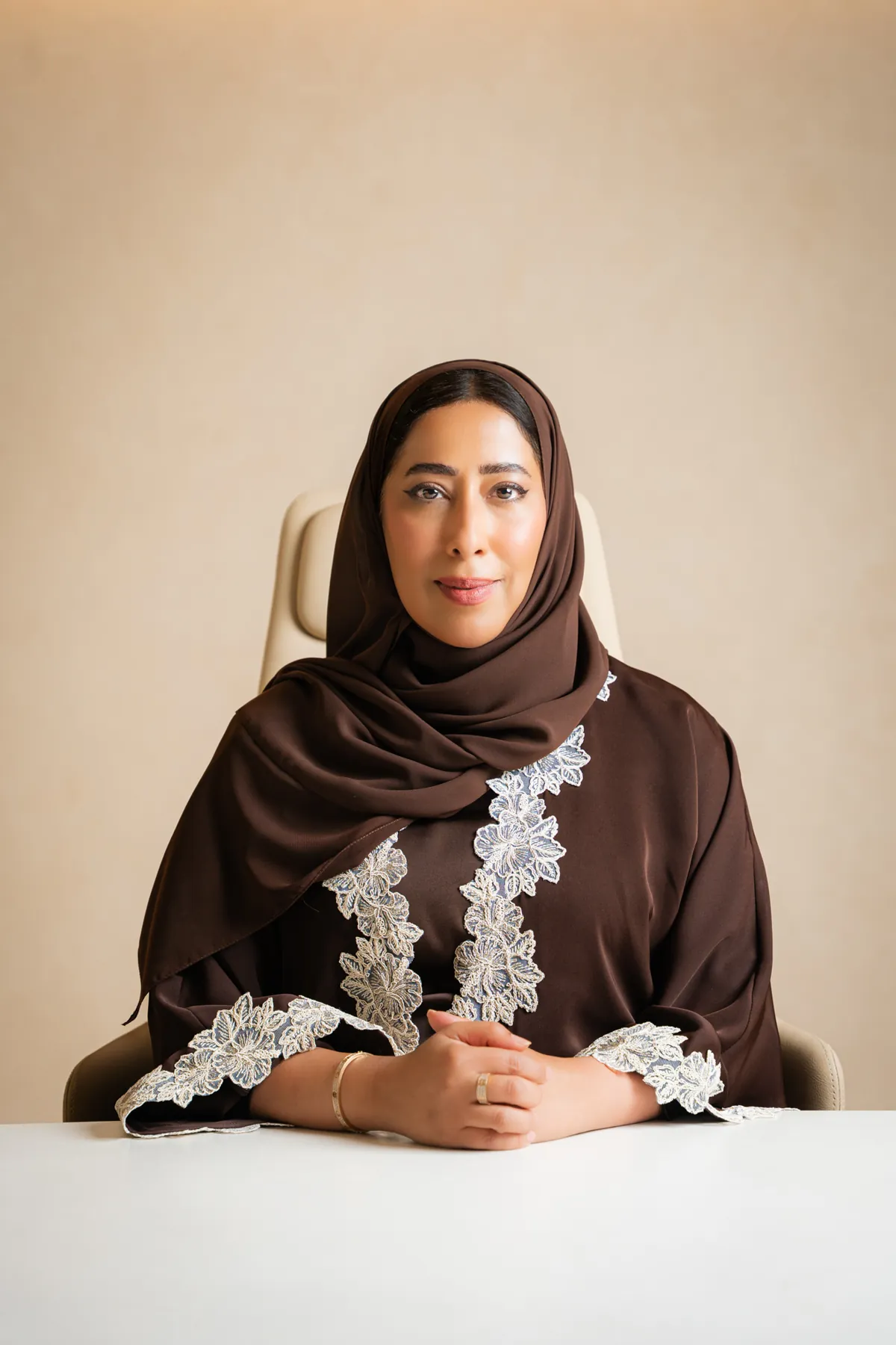 Emirati businesswoman seated at a white desk