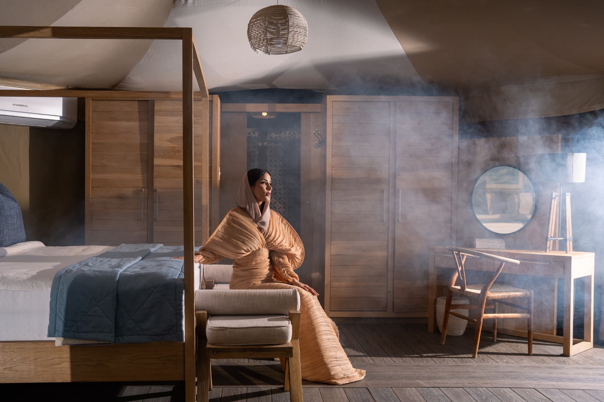 Woman in a draped robe in a misty wooden bedroom