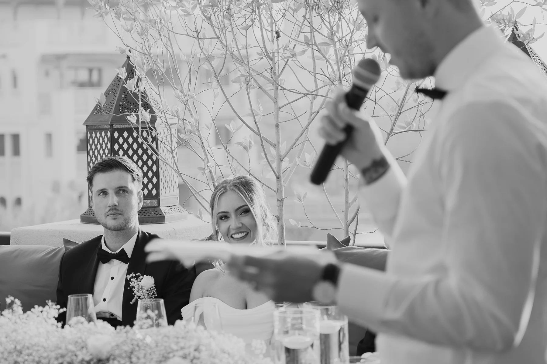 Groom speaking at the reception, black and white