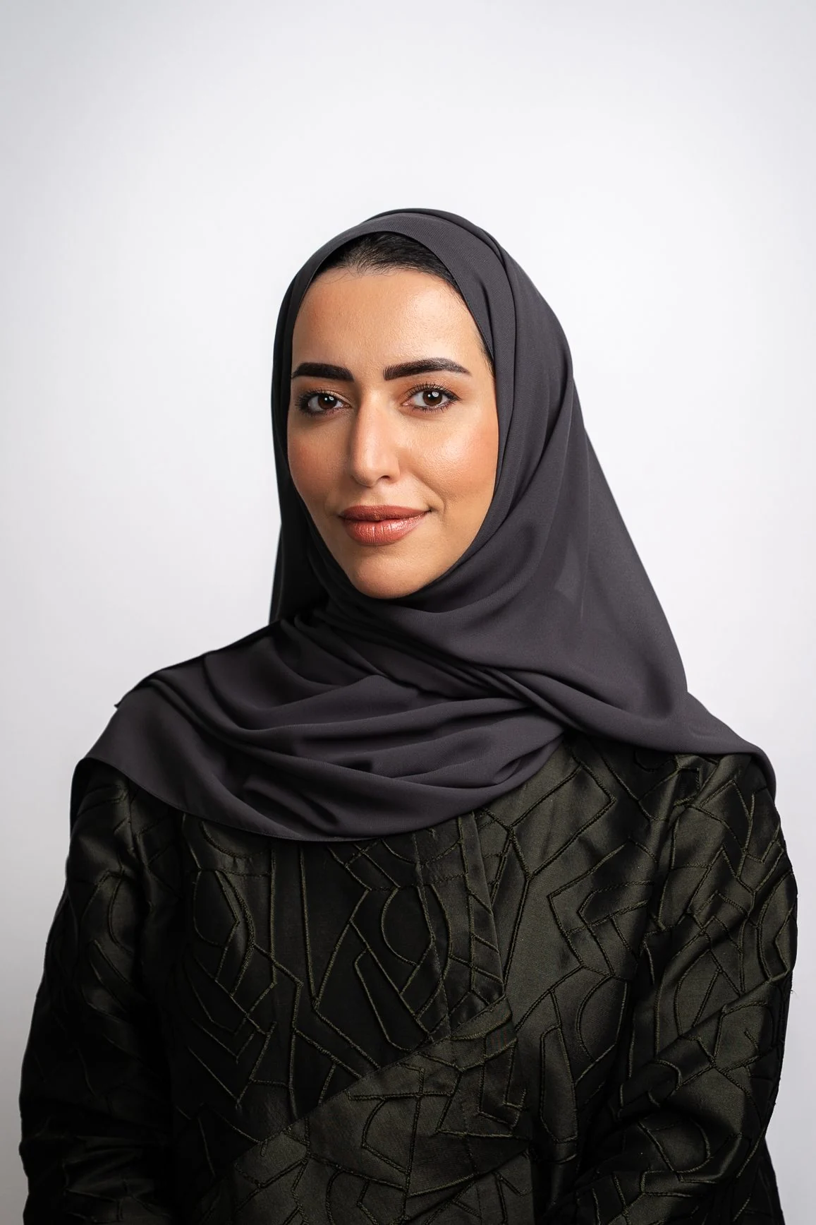 Corporate headshot of an Emirati woman in a black shayla